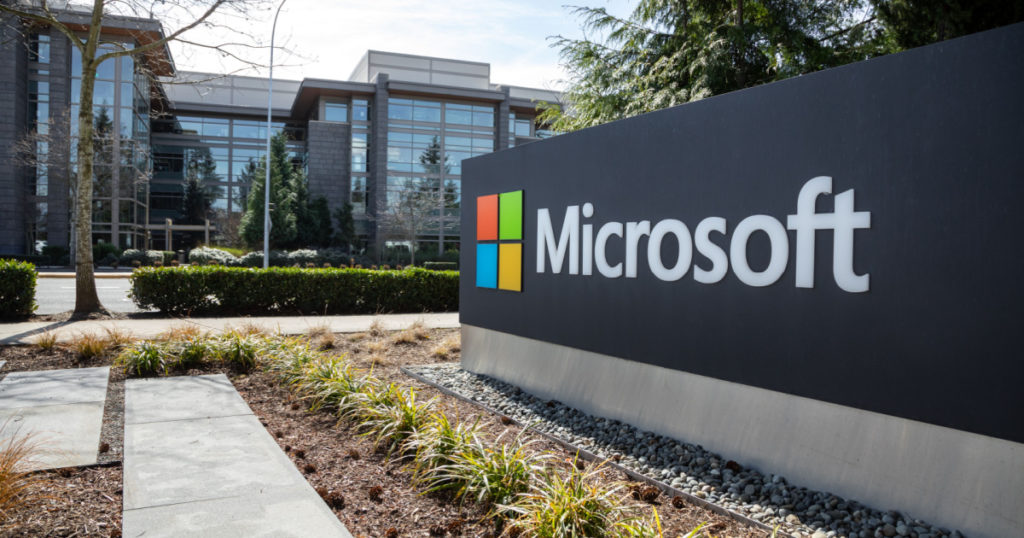 Redmond, Washington / USA - March 28 2019: Wide angle view of a Microsoft sign at the headquarters for the software and hardware company, with office building in the background
