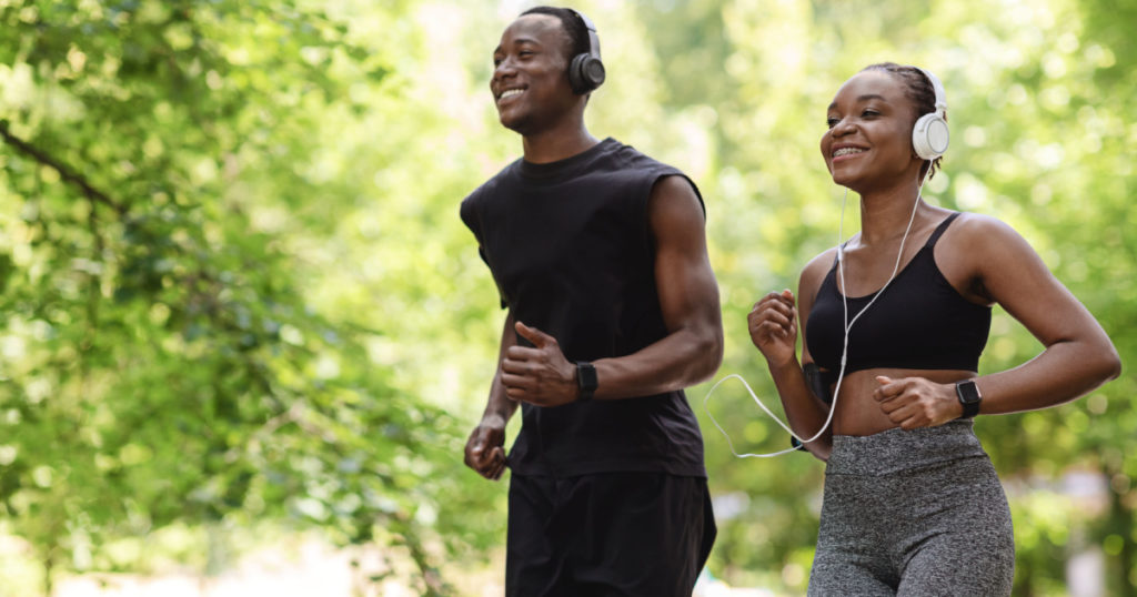 Jogging Couple. Happy Black Guy And Girl Running In Morning Park Together, Feeling Healthy And Motivated, Copy Space
