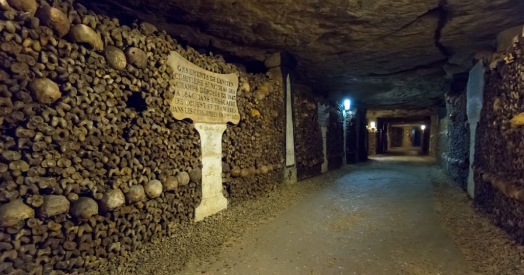 Catacombs of Paris, France. Famous Catacombs (Les catacombes de Paris) are underground ossuaries and tourist attraction, museum in old vault. Scary tunnel with human bones, crypt. Paris - Oct 25, 2013
