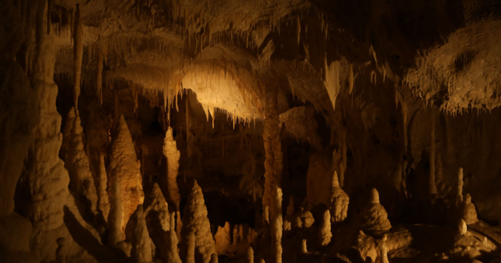 Many stalactite and stalagmite formations inside cave
