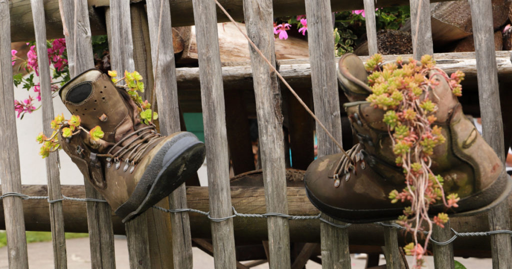 old hiking boots hanging on a fence
