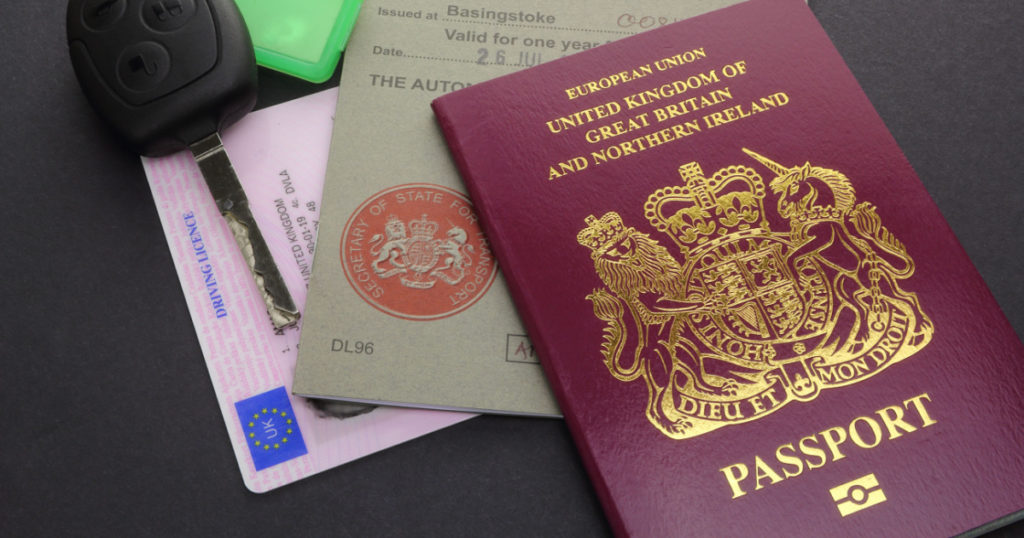 CAMBRIDGE, UK - JULY 14, 2016: United Kingdom or British EU Passport with International Driving Permit, Driving Licence, and Car Key - illustrative editorial
