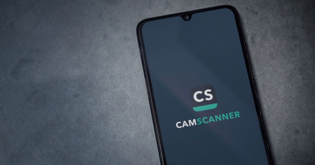 Lod, Israel - July 8, 2020: CamScanner app launch screen with logo on the display of a black mobile smartphone on dark marble stone background. Top view flat lay with copy space.
