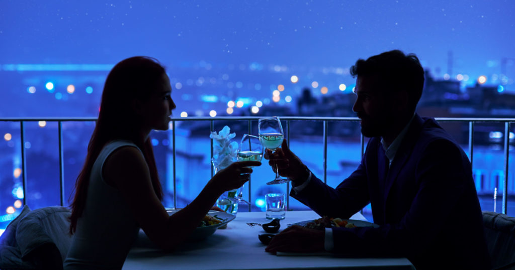 Young couple at restaurant having dinner. Silhouette
