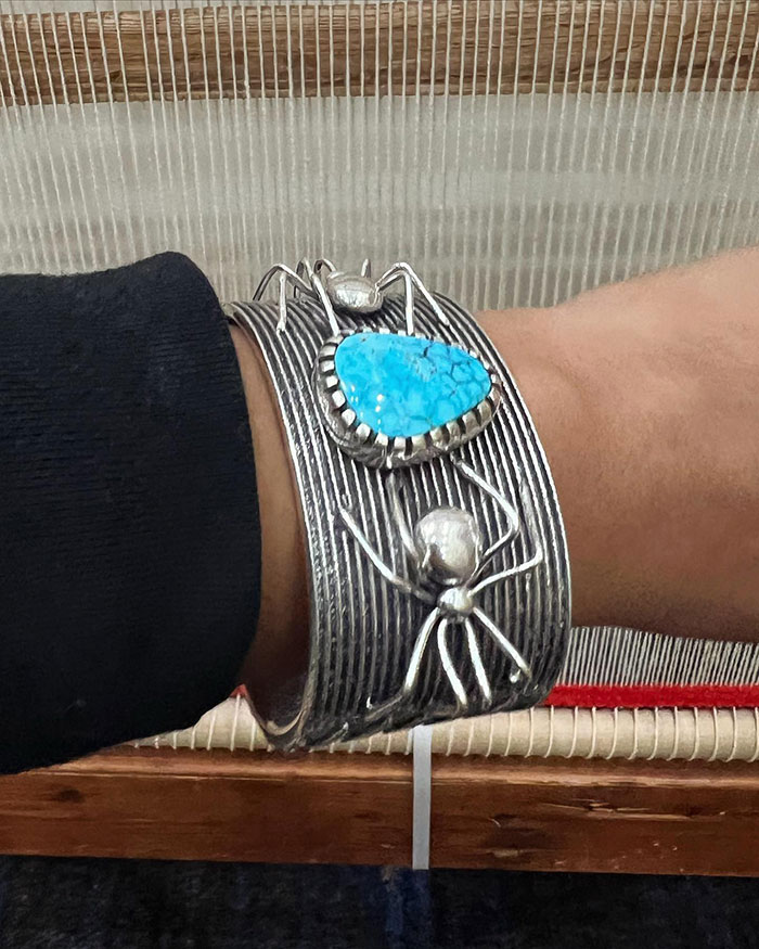 Naiomi's distinctive style seamlessly blends traditional Diné woven textiles and turquoise jewelry with contemporary elements such as denim jackets, skirts, and sneakers