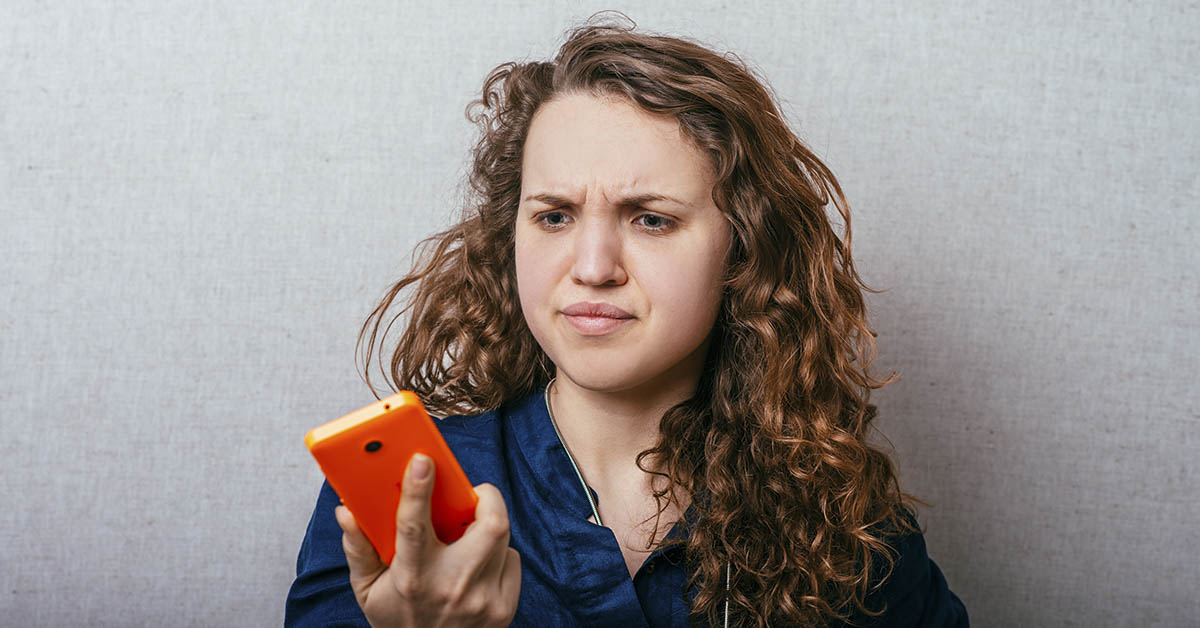 woman looking at phone surprised