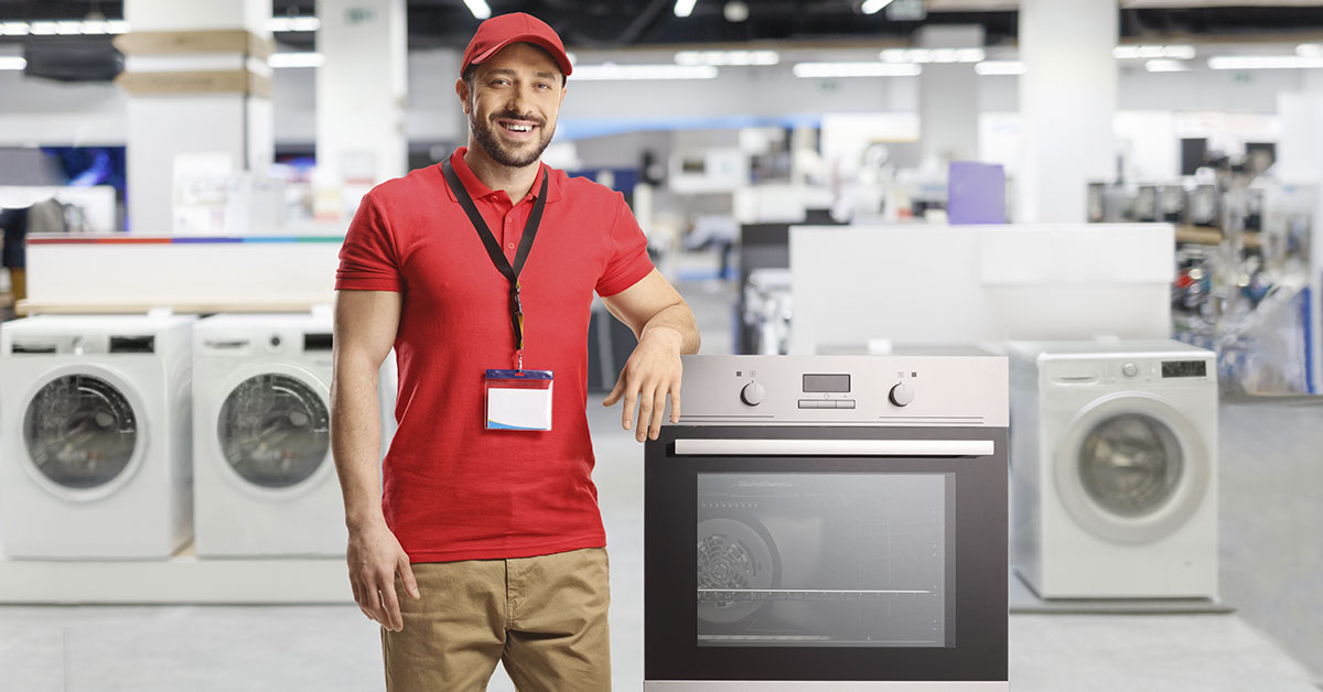 Salesman standing next to stove in appliance store