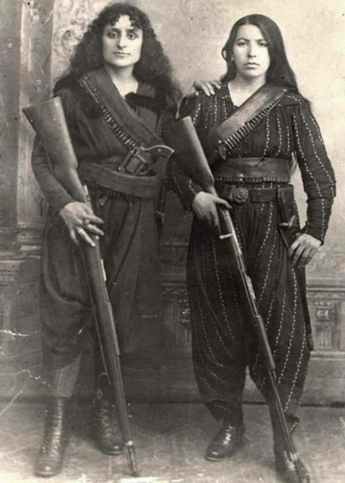 In a compelling snapshot from 1895, two Armenian women exude strength and resilience as they pose proudly with their rifles, preparing to join the battle against the Ottoman forces