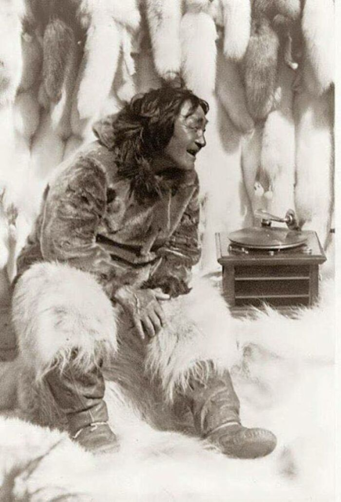 1922, a captivating photograph captures the joyous moment of a Nanook man experiencing the magic of music on a record player