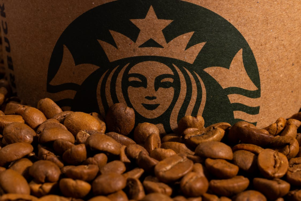 Photo of Brown Coffee Beans Beside a Starbucks Logo
