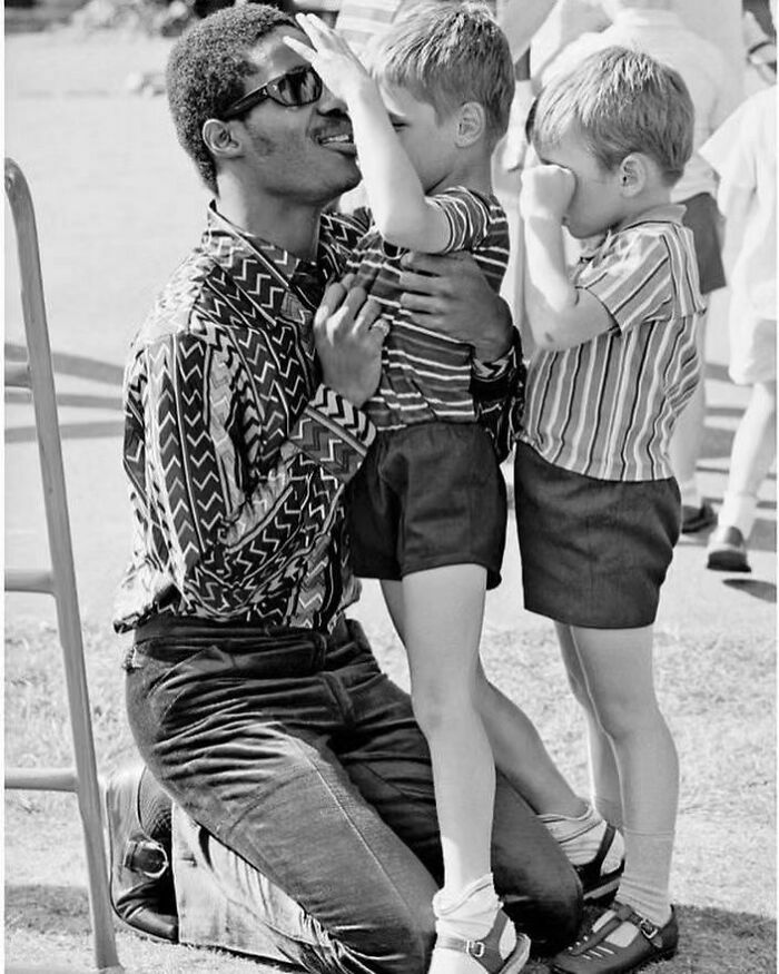 Stevie Wonder spending time with students from a school for the blind in London, 1970