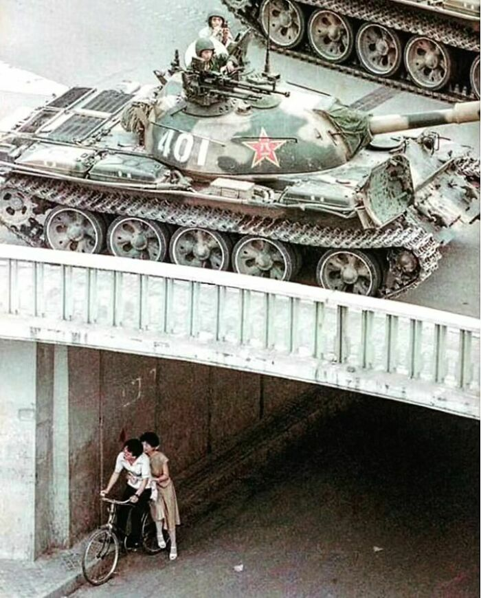 In the aftermath of the Tiananmen Square Massacre in 1989, a gripping photograph captures the profound human impact, depicting a man and a woman seeking refuge under a bridge.