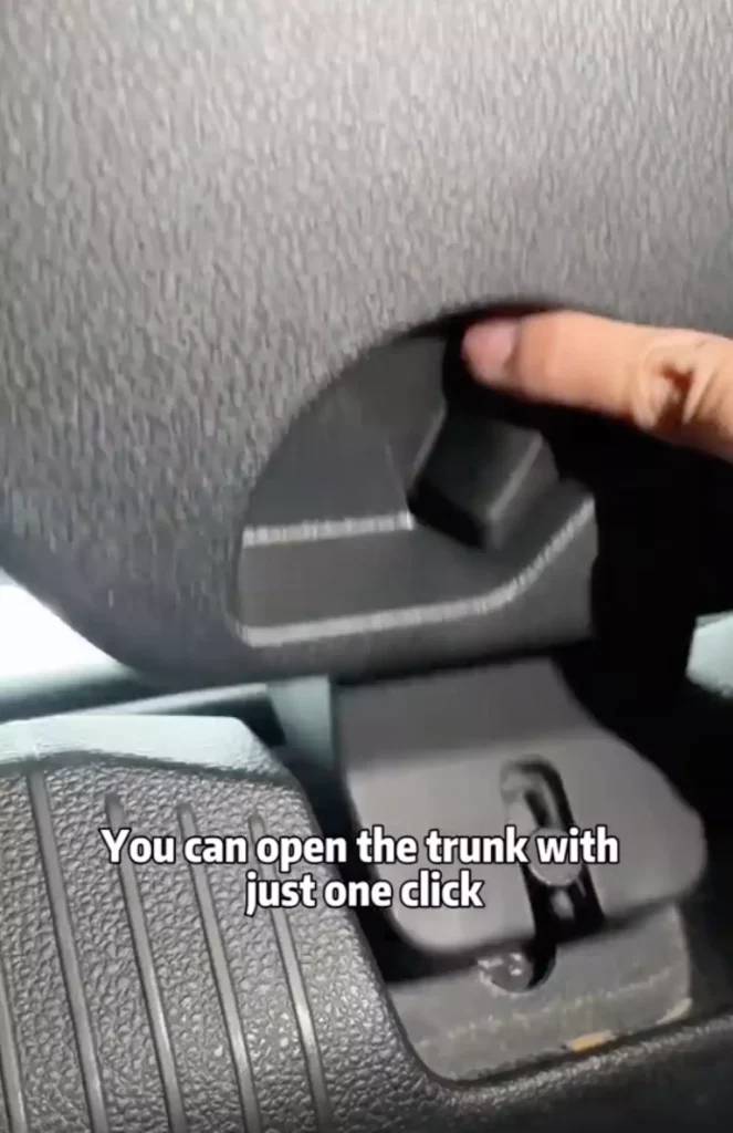 Finger pressing a lever in a vehicle.
