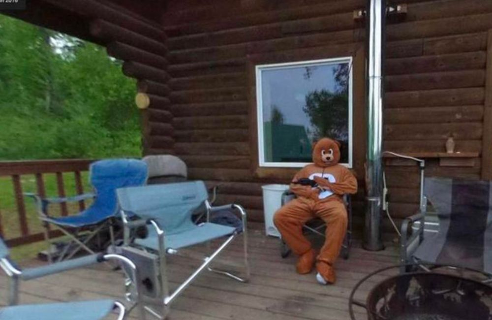 This alarming photo from 2016 features a man in a bear costume standing in front of a log cabin.
