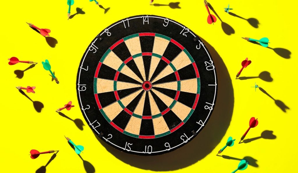dart board hit or miss on yellow background